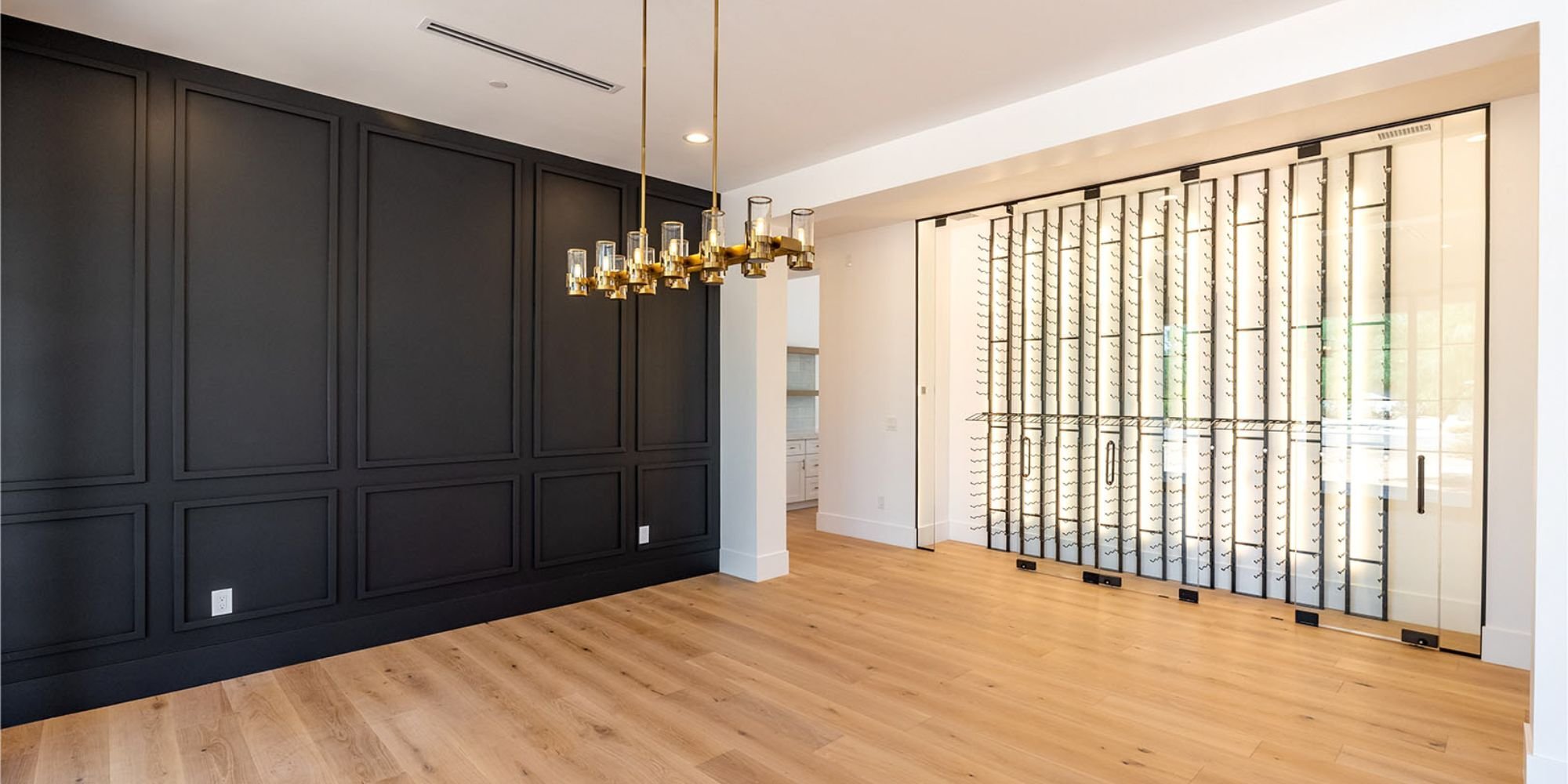 Elegant dining room addition in Scottsdale AZ by Trinity Homes AZ featuring black accent wall and glass wine display