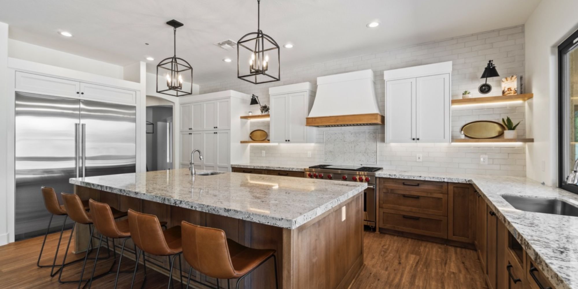 Home addition kitchen in Scottsdale by Trinity Homes AZ with white upper cabinets, wood base cabinets, and stainless steel appliances