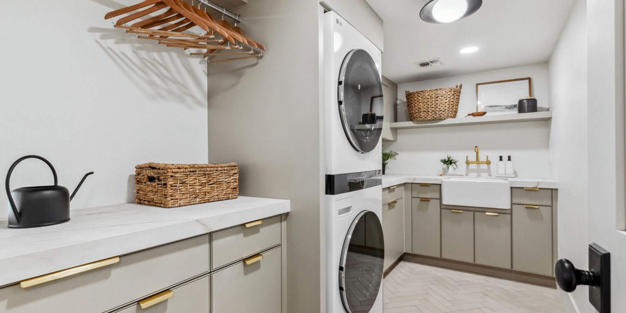 Modern Arizona laundry room renovation by Trinity Homes featuring sleek cabinets and brass hardware