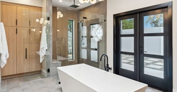 Modern freestanding bathtub and glass shower in a luxury whole home remodel by Trinity Homes in Arizona