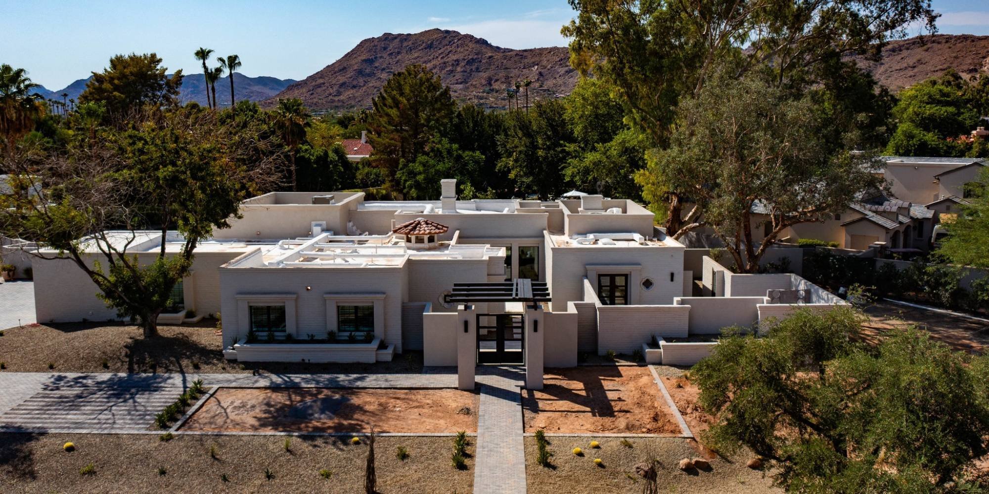 Modern custom home in Scottsdale, AZ with desert landscaping and mountain views by Trinity Homes AZ