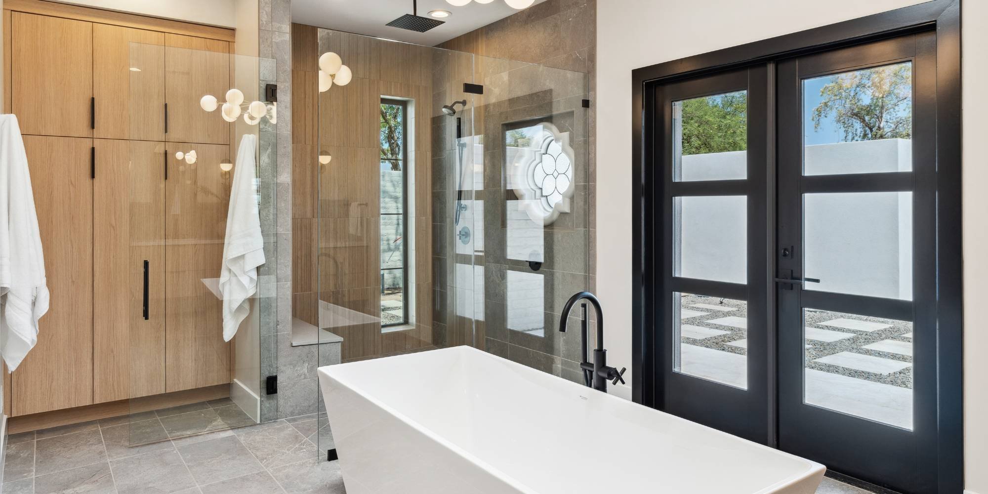 Scottsdale bathroom remodel by Trinity Homes featuring sleek tile, wood cabinetry, and spa design