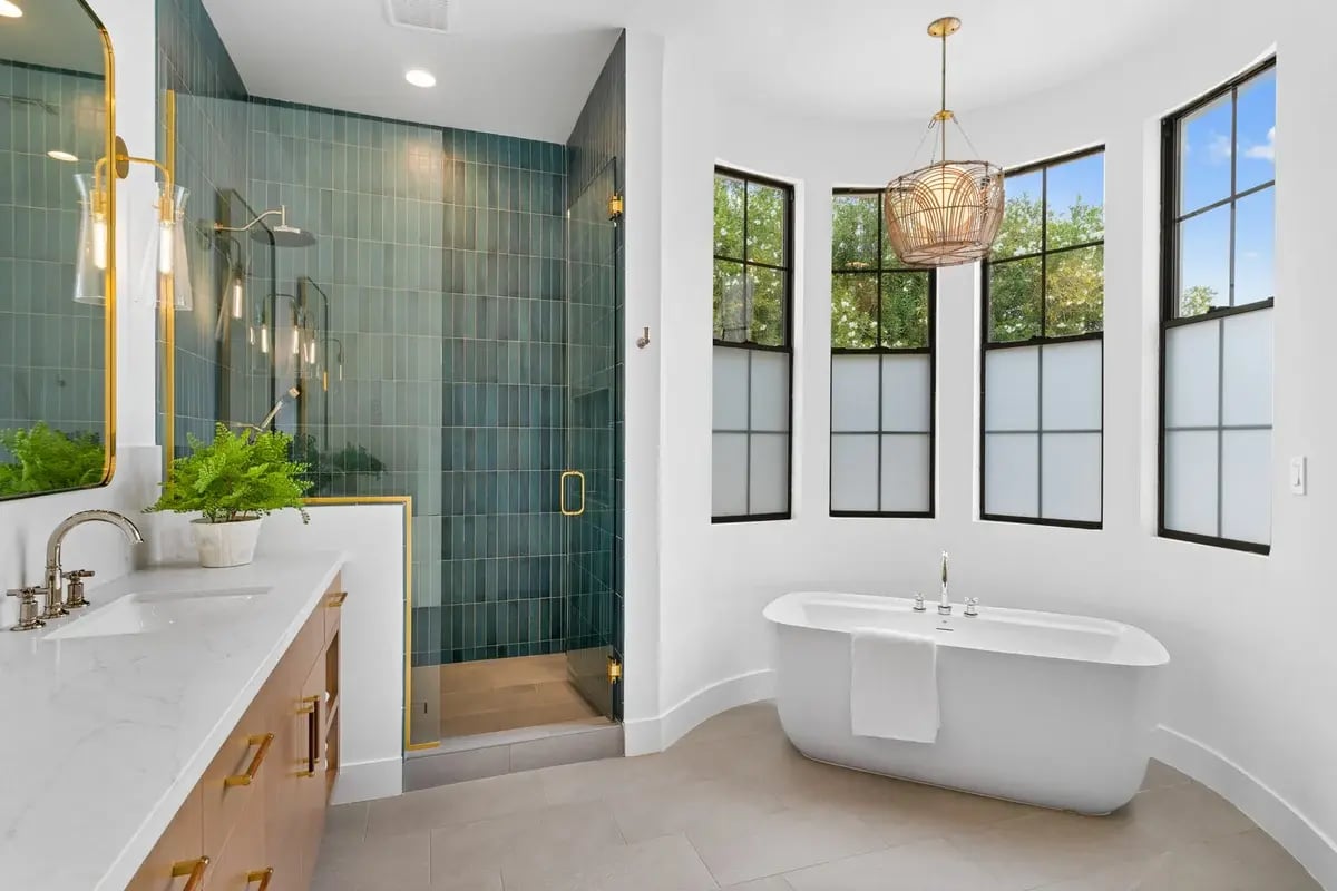 Master bathroom tub alcove with curved white wall and frosted windows by Trinity Homes AZ in Scottsdale, AZ