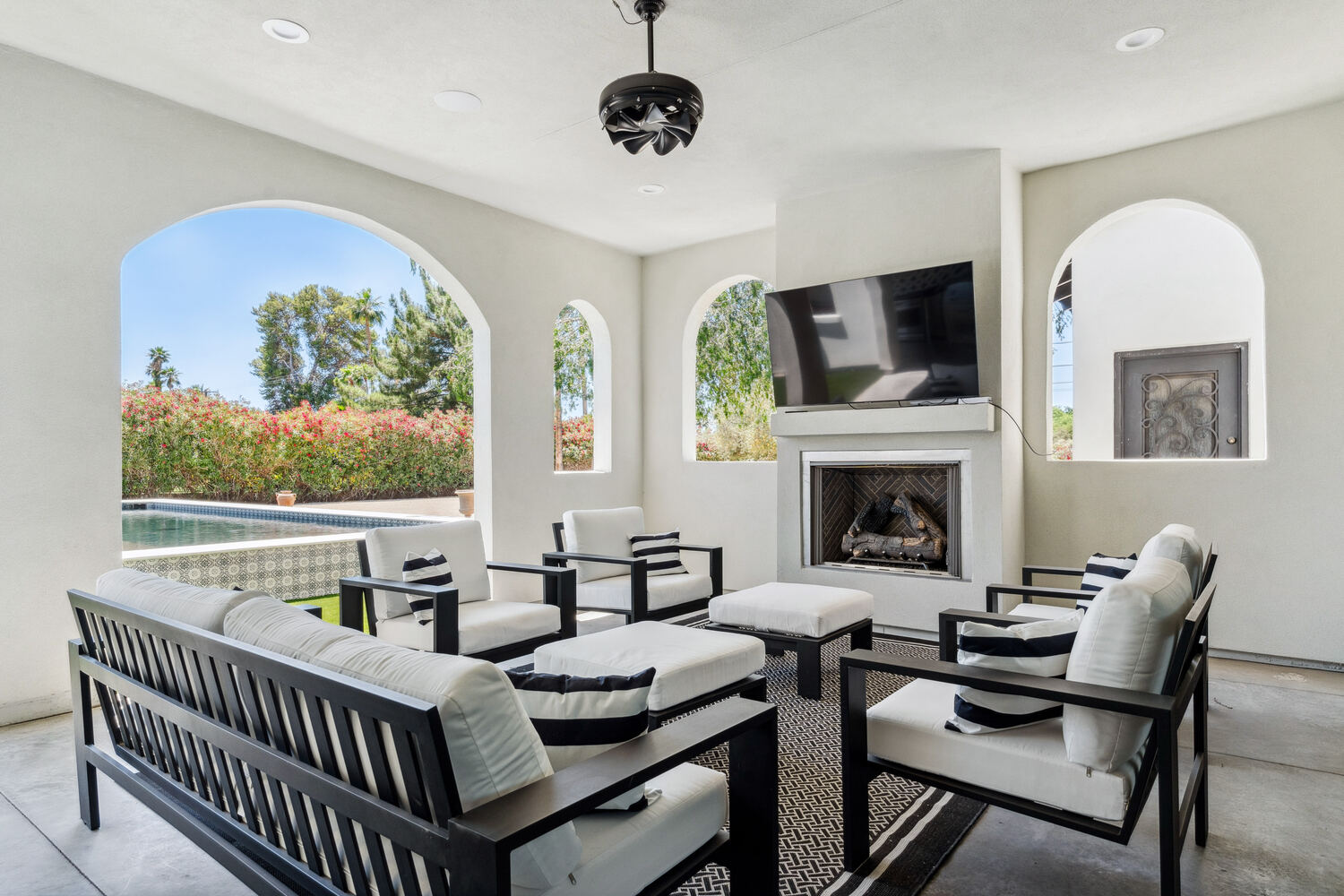 Outdoor living room with fireplace and pool, part of a whole home remodel by Trinity Homes in Phoenix, AZ