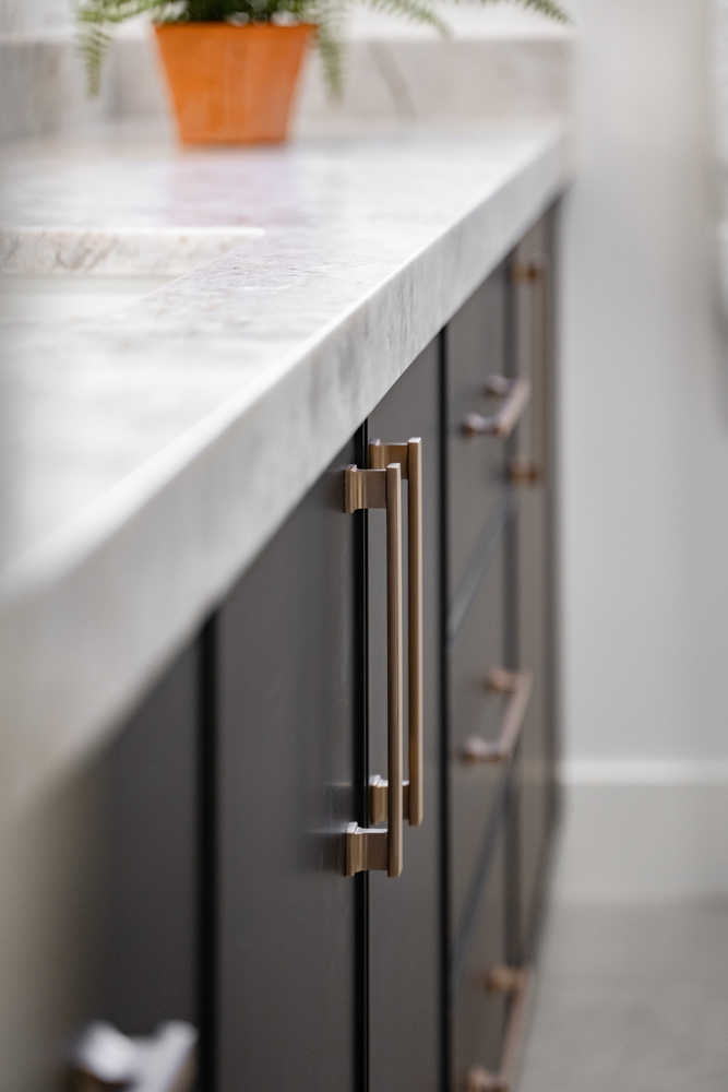 Close-up of modern vanity with gold hardware and marble countertop from Trinity Homes bathroom remodel in Phoenix