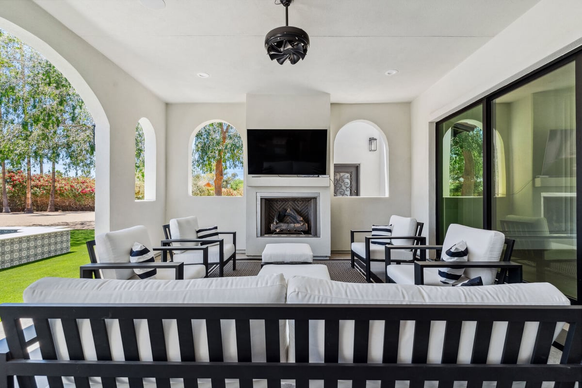 Covered outdoor living space with fireplace and TV in Scottsdale remodel by Trinity Homes