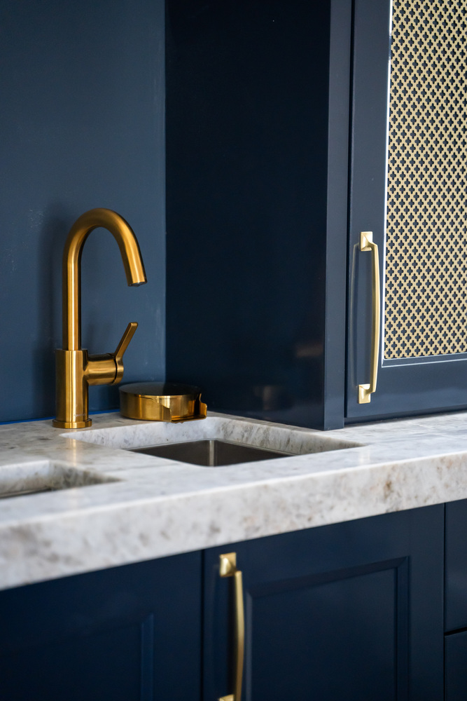 Gold kitchen faucet and marble countertop close-up in Scottsdale remodel by Trinity Homes