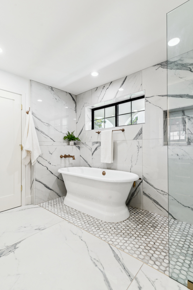 Modern master shower in Scottsdale remodel by Trinity Homes with marble tile and brass fixtures