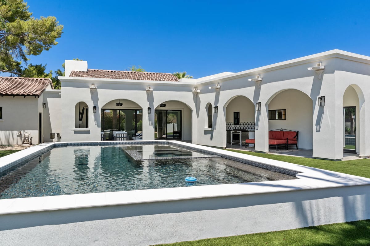 Rear exterior view of remodeled home with pool and covered patio by Trinity Homes in Phoenix, AZ