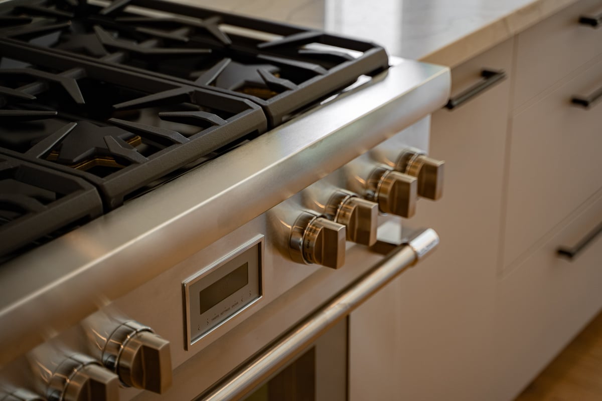 Close-up of stainless steel range and burner knobs in Paradise Valley kitchen by Trinity Homes