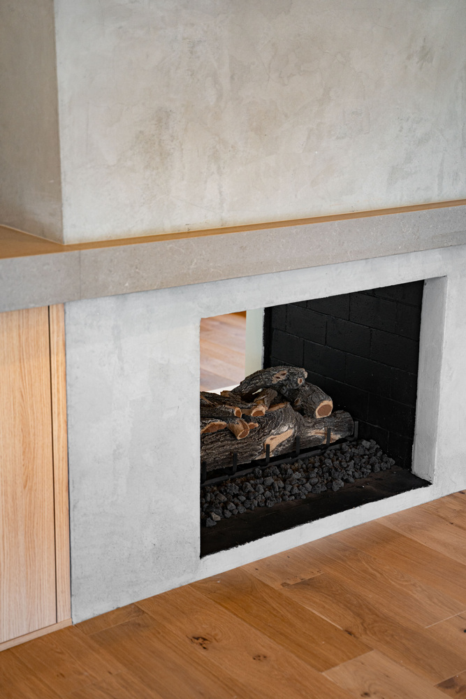 Concrete-faced double-sided fireplace with stacked logs in Paradise Valley living room by Trinity Homes