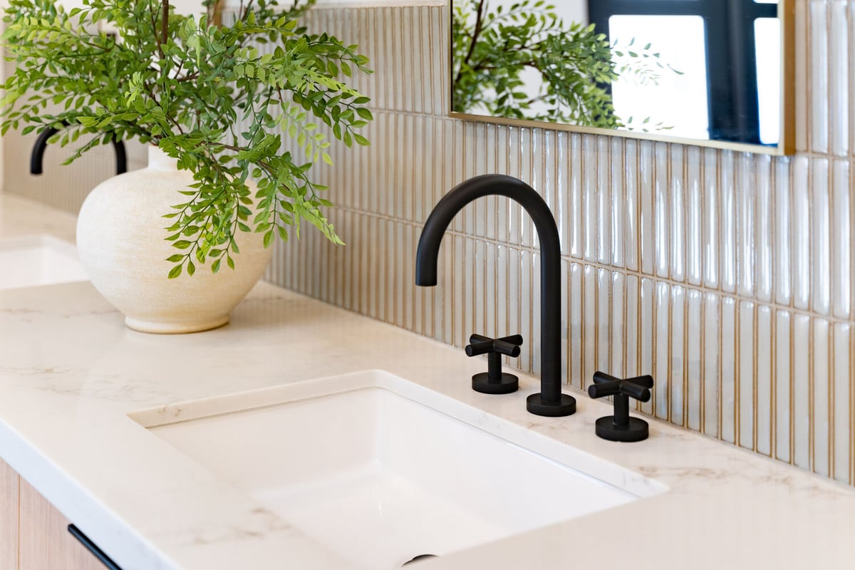 Dual sink vanity with matte black faucet and decorative backsplash in Paradise Valley remodel by Trinity Homes