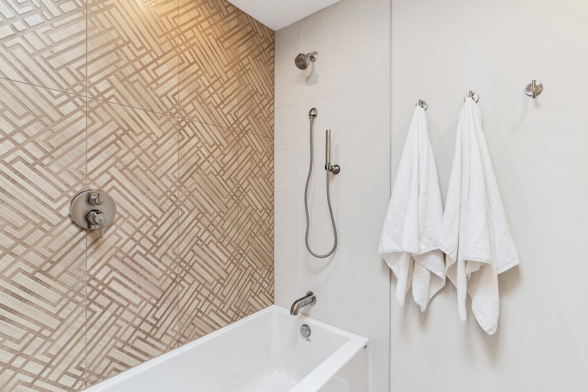 Modern bathroom shower remodel with geometric tile pattern by Trinity Homes in Paradise Valley