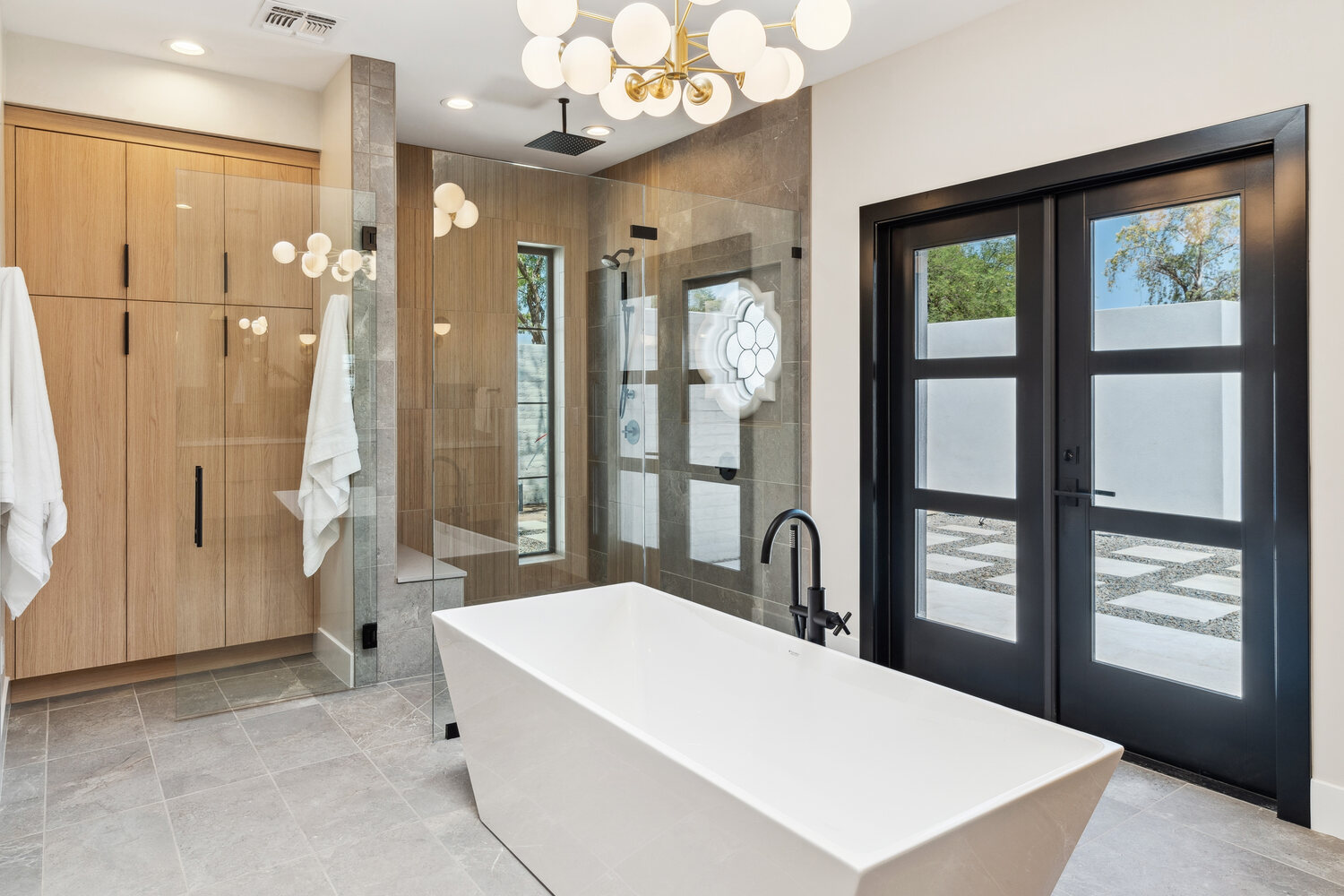 Modern bathroom with soaking tub and floor-to-ceiling glass shower by Trinity Homes in Paradise Valley