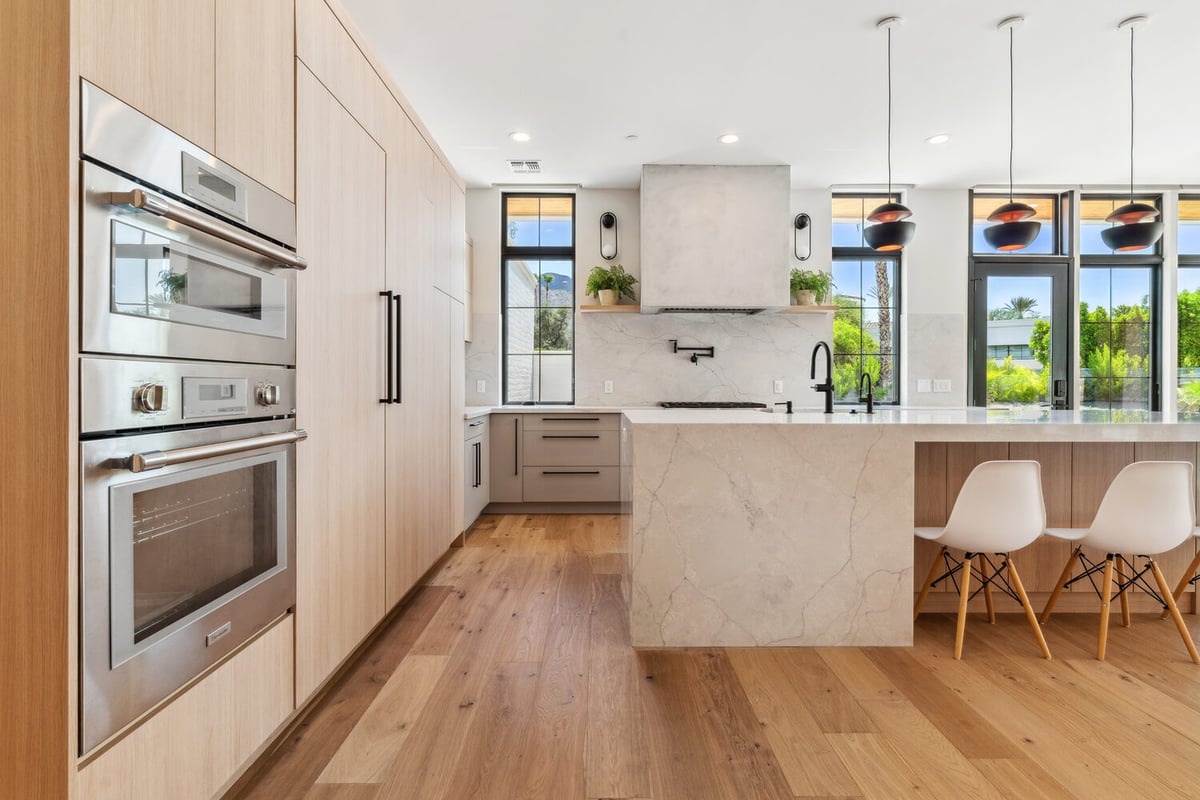 Modern kitchen remodel with marble island and double oven by Trinity Homes in Paradise Valley