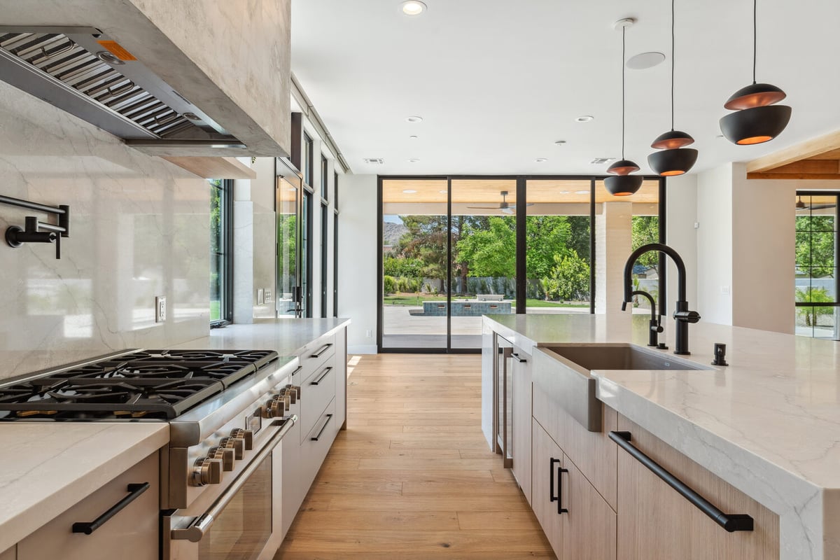 Open kitchen design with large island and panoramic patio view by Trinity Homes in Paradise Valley