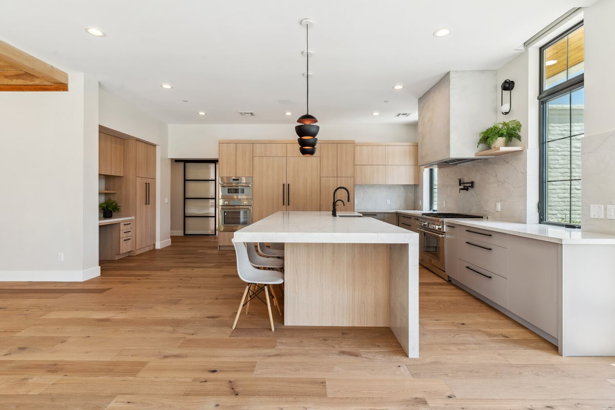 Spacious custom kitchen with dual ovens and waterfall island by Trinity Homes in Paradise Valley