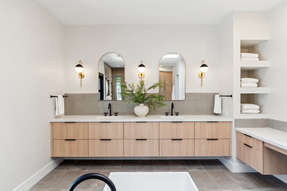 Wide angle of luxury bathroom renovation with dual sinks and built-in shelving by Trinity Homes in Paradise Valley