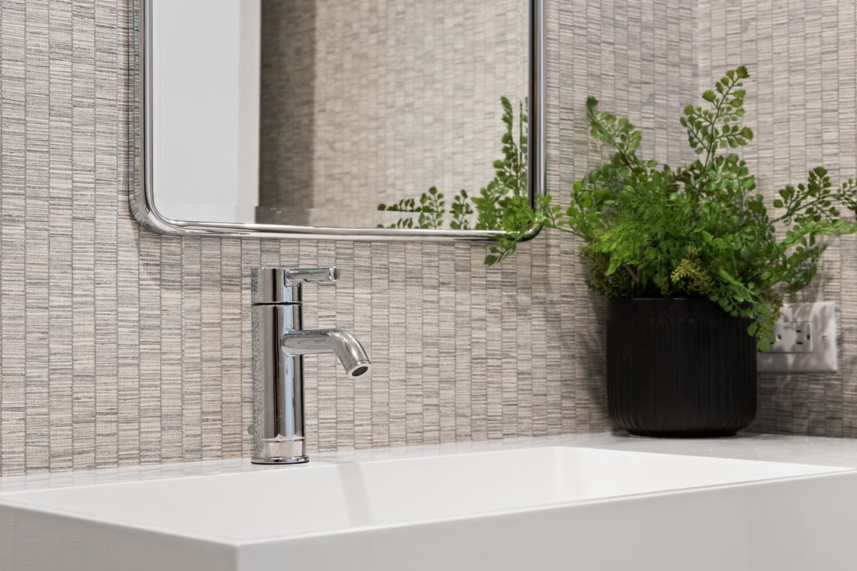 Chrome faucet and greenery decor in modern bathroom by Trinity Homes in Scottsdale, AZ