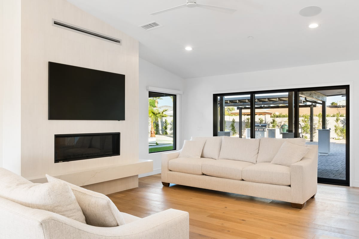 Close-up of marble fireplace ledge with wood flooring in Scottsdale AZ living room by Trinity Homes