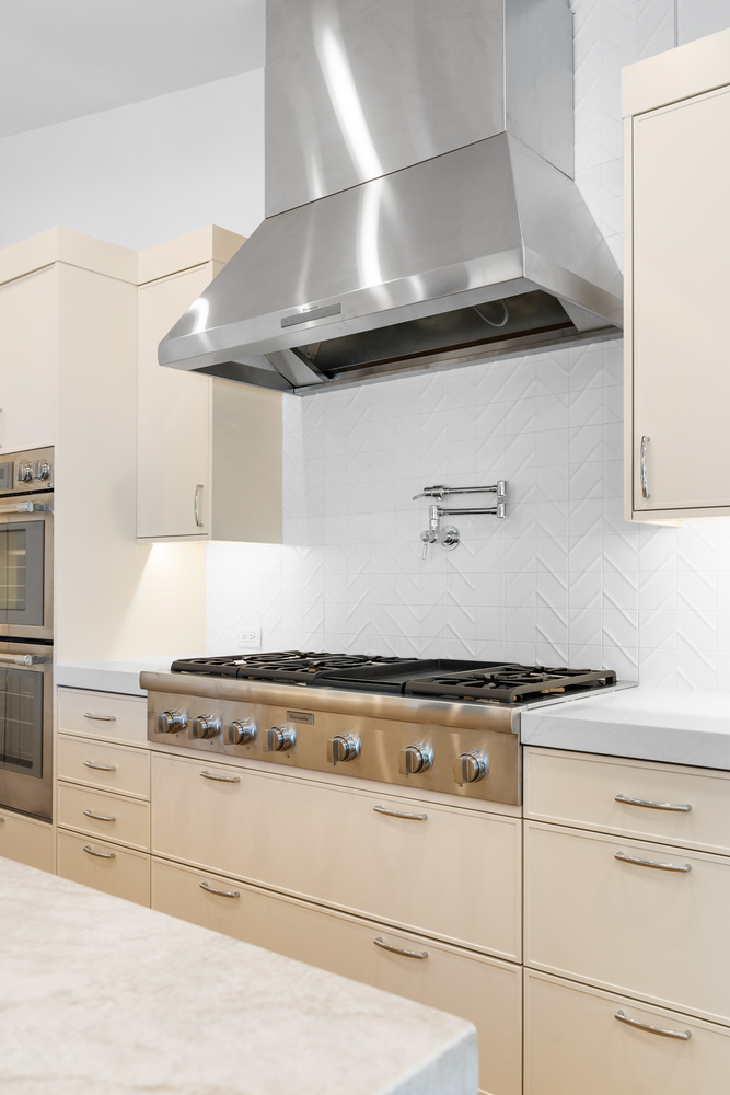 Full view of modern kitchen with stainless steel range hood in Scottsdale remodel by Trinity Homes