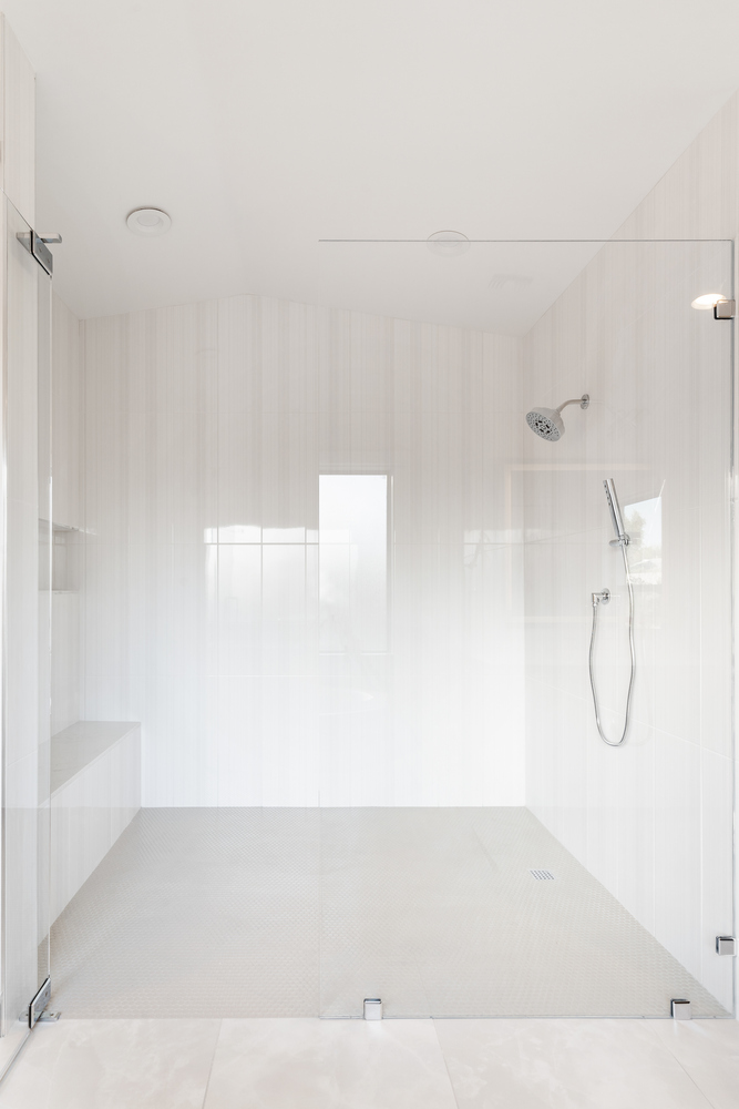 Full-width walk-in shower with dual heads and bench in Scottsdale home renovation