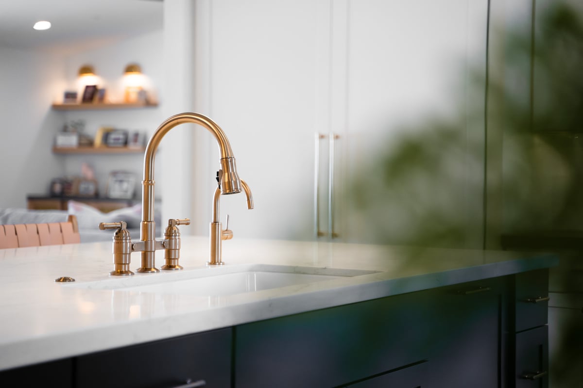 Brass kitchen faucet detail with quartz countertop by Trinity Homes AZ in Paradise Valley, AZ
