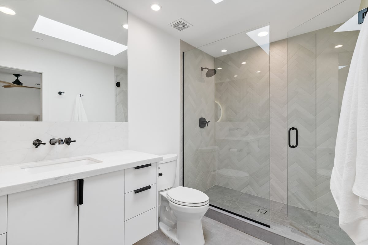 Bright custom bathroom with glass shower and marble vanity by Trinity Homes AZ in Scottsdale, AZ