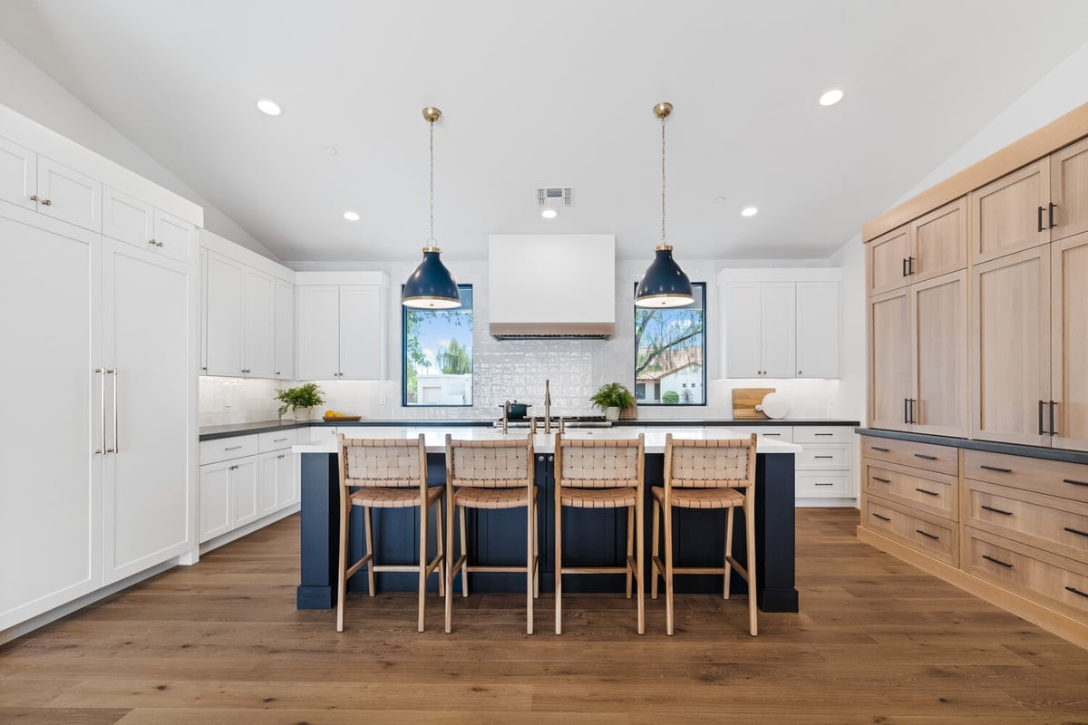 Bright custom kitchen with pendant lights and bar stools by Trinity Homes AZ in Chandler, AZ