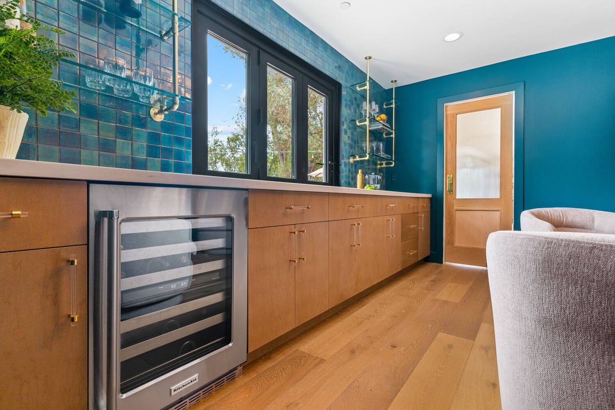 Built-in bar cabinetry with wine fridge and gold hardware by Trinity Homes AZ in Chandler, AZ
