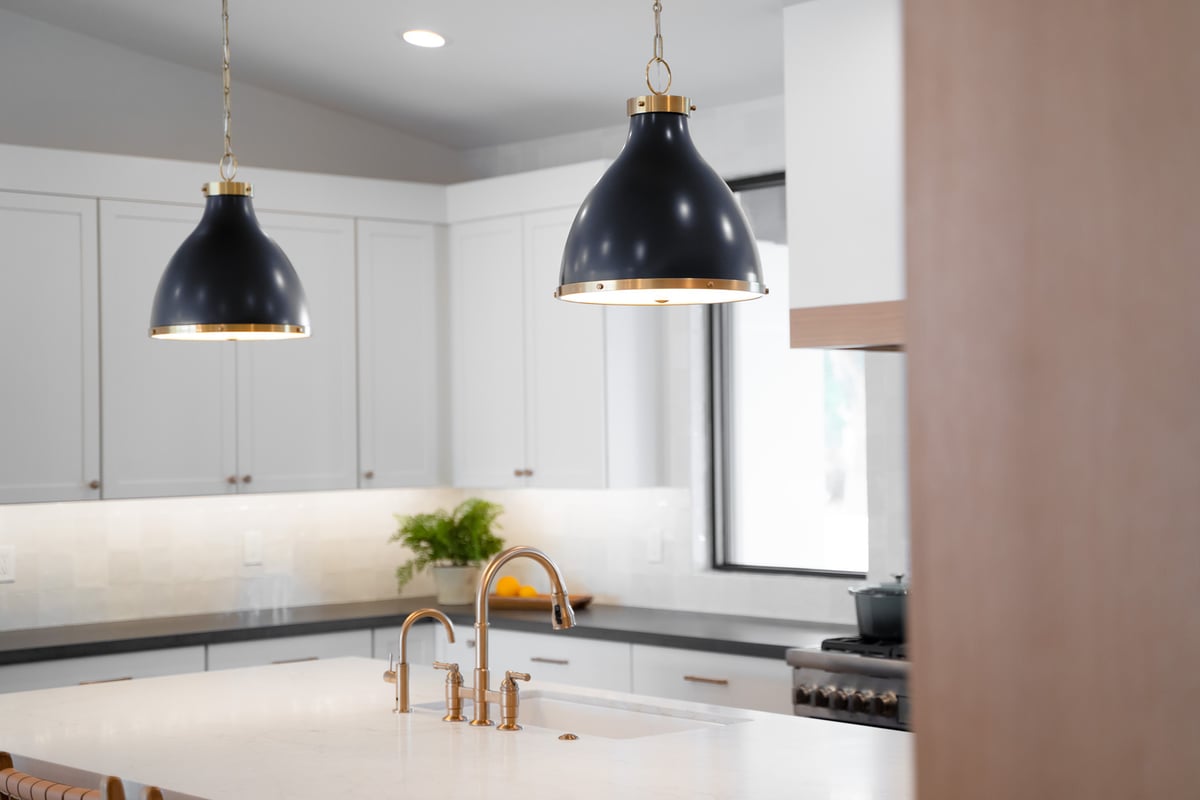 Close-up of black and gold pendant lights in kitchen by Trinity Homes AZ in Scottsdale, AZ