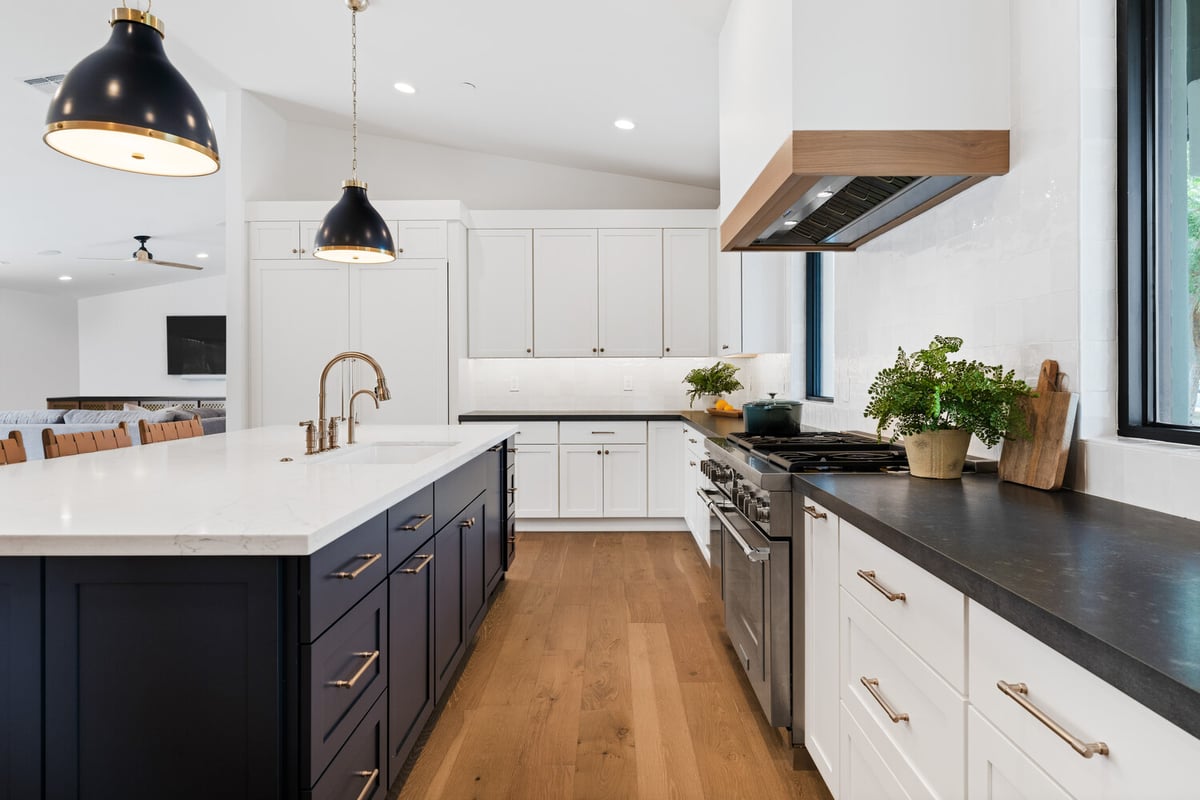 Custom home kitchen with wide-plank floors and white cabinetry by Trinity Homes AZ in Chandler, AZ