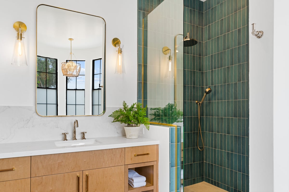 Custom shower with green vertical tiles and rainfall showerhead by Trinity Homes AZ in Arcadia, AZ