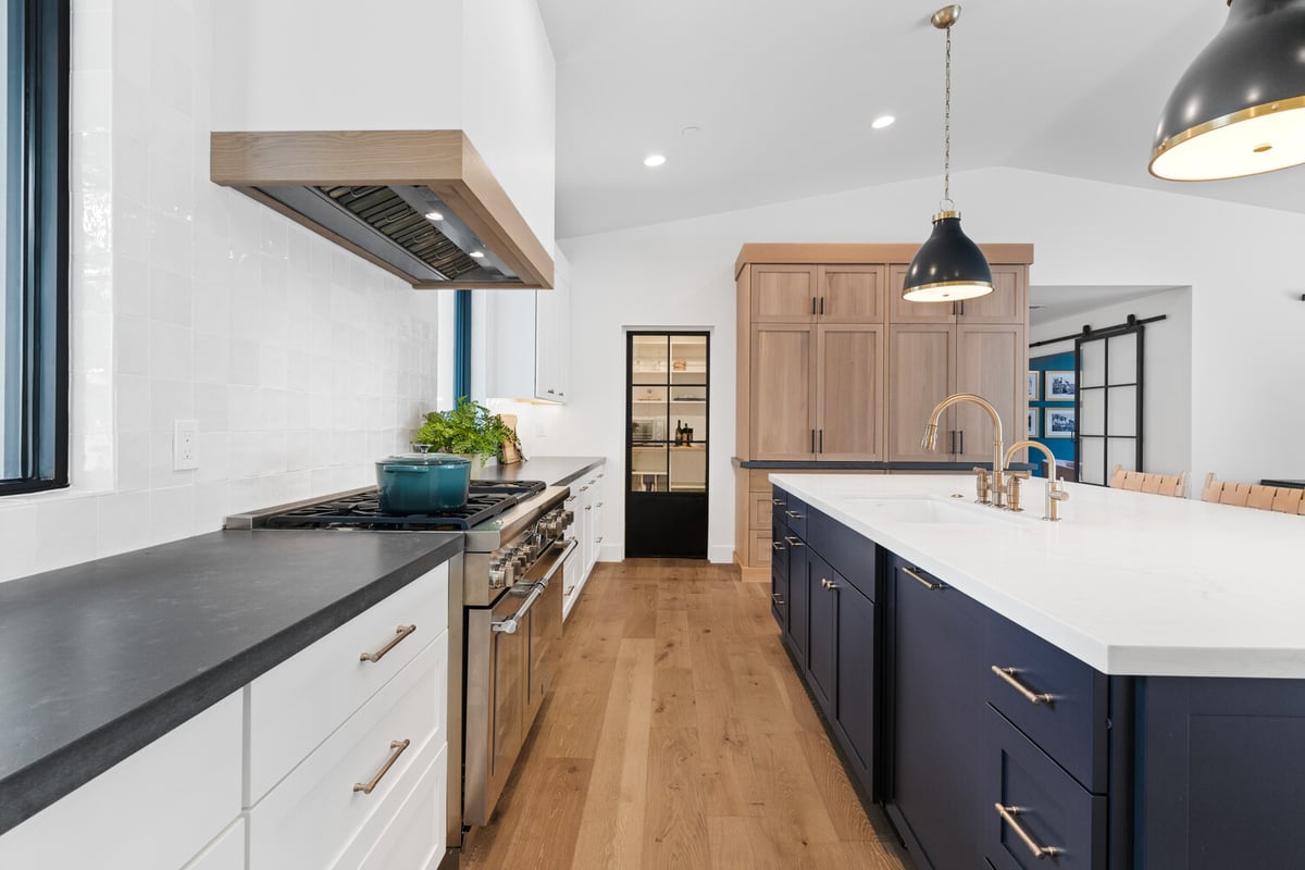 Elegant kitchen renovation featuring navy island and brass fixtures by Trinity Homes AZ in Gilbert, AZ