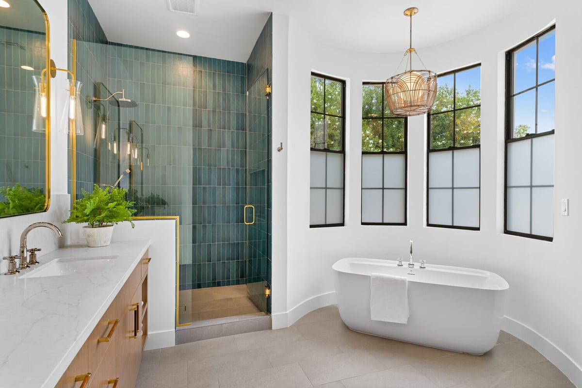 Master bathroom tub alcove with curved white wall and frosted windows by Trinity Homes AZ in Scottsdale, AZ