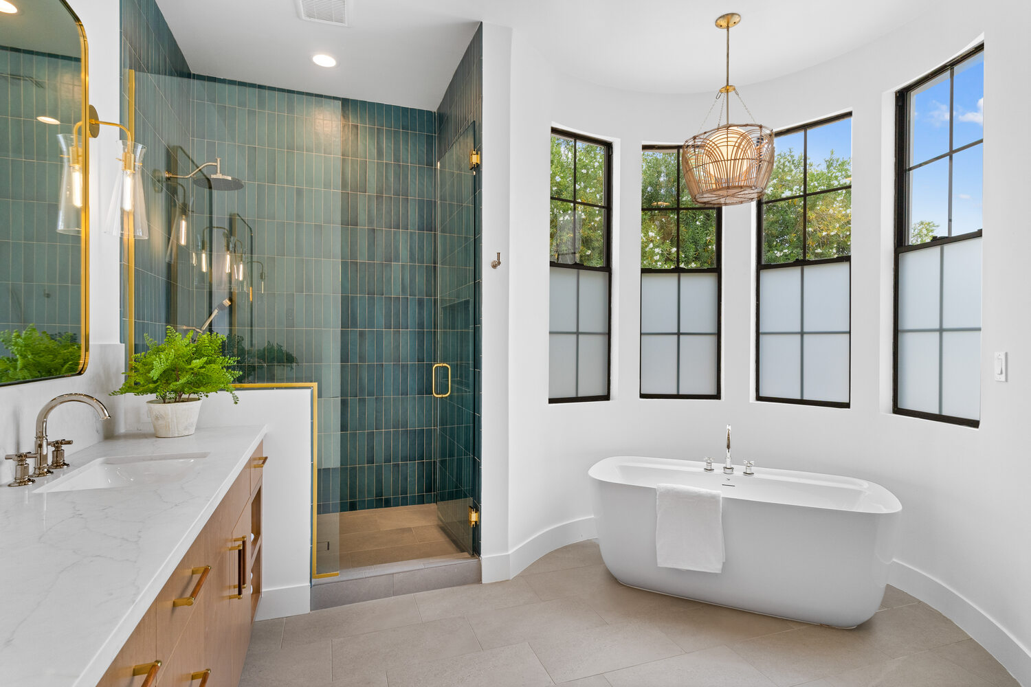 Master bathroom tub alcove with curved white wall and frosted windows by Trinity Homes AZ in Scottsdale, AZ