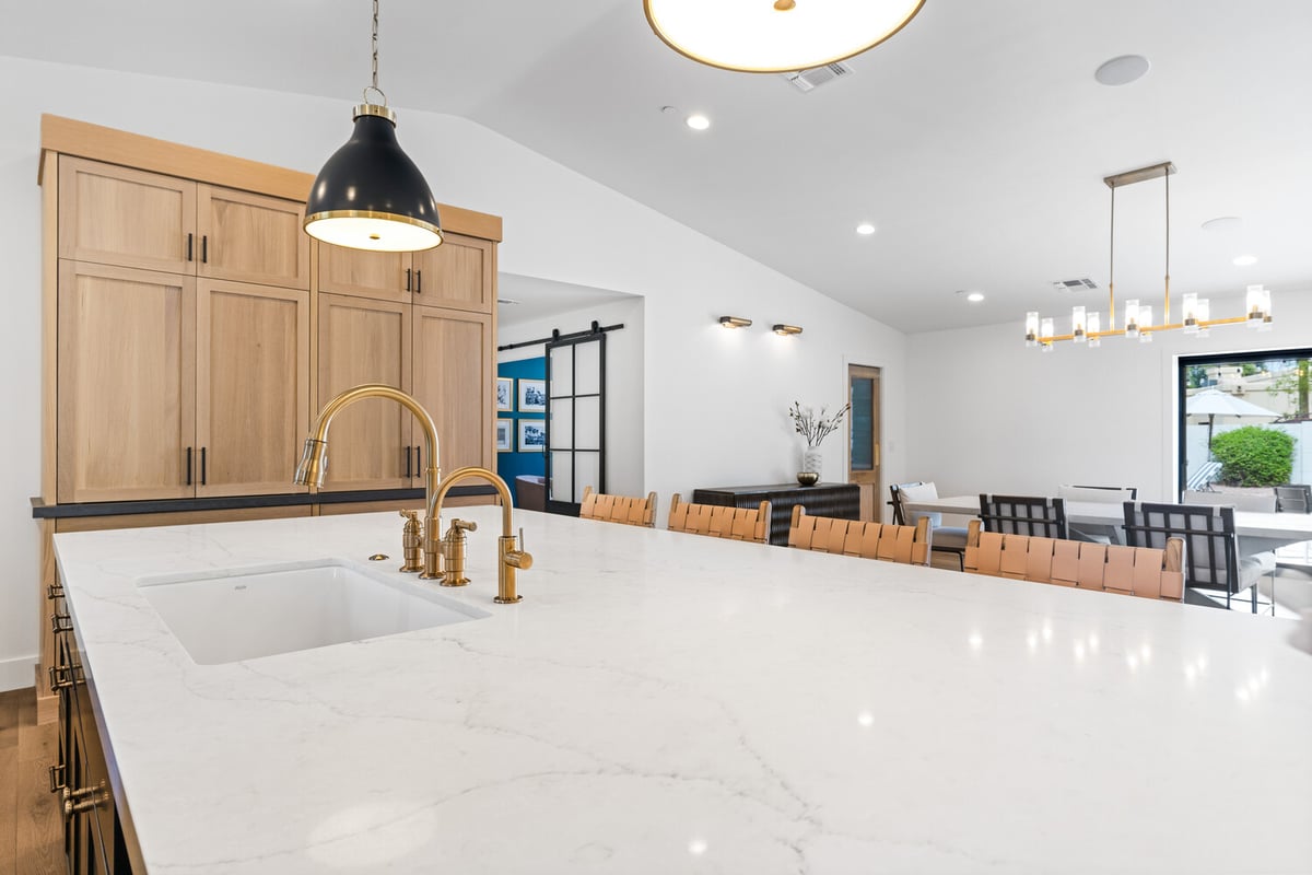 Modern farmhouse kitchen with pendant lights and wood cabinetry by Trinity Homes AZ in Cave Creek, AZ