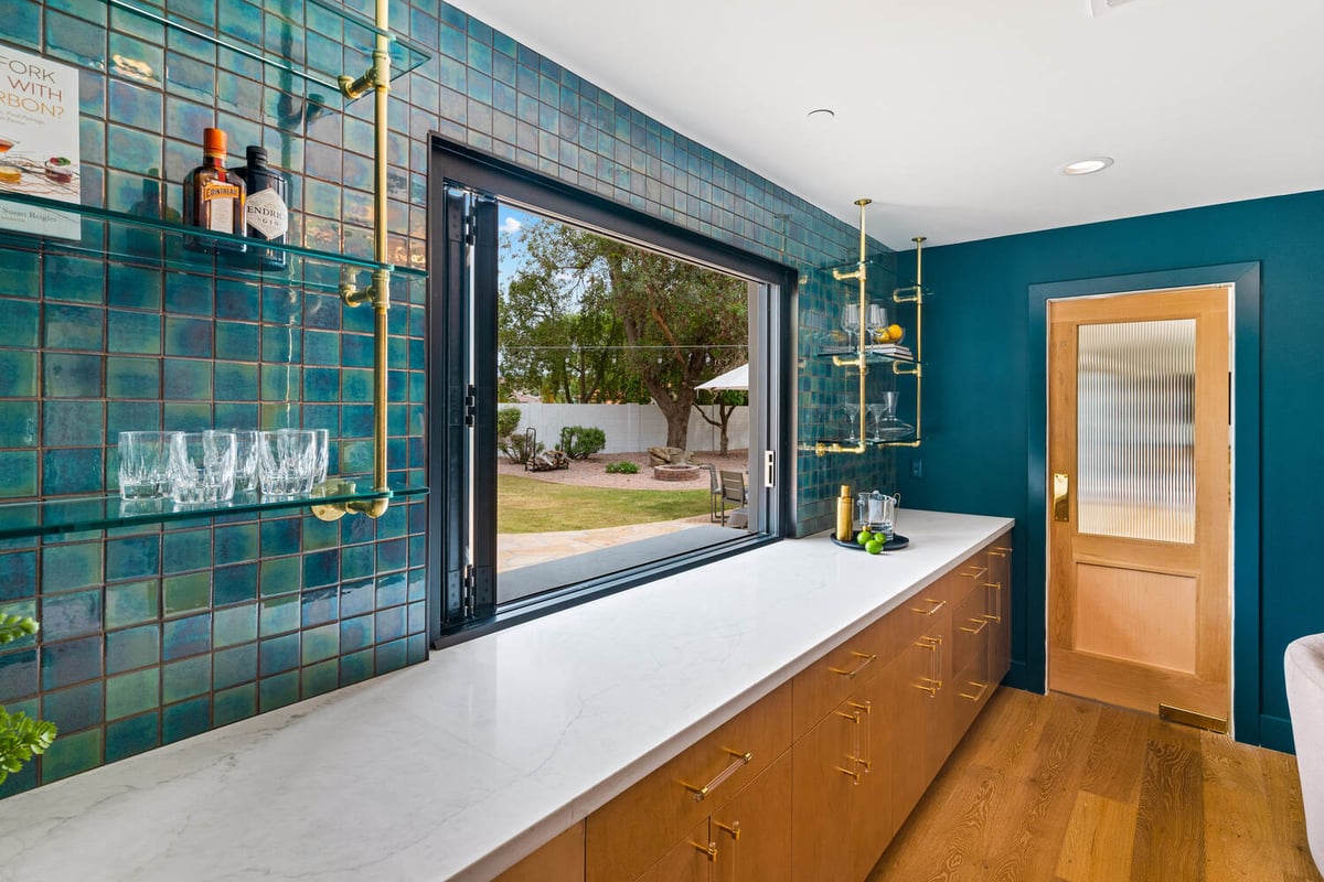 Open bar window design with teal backsplash and gold-accent shelving by Trinity Homes AZ in Mesa, AZ