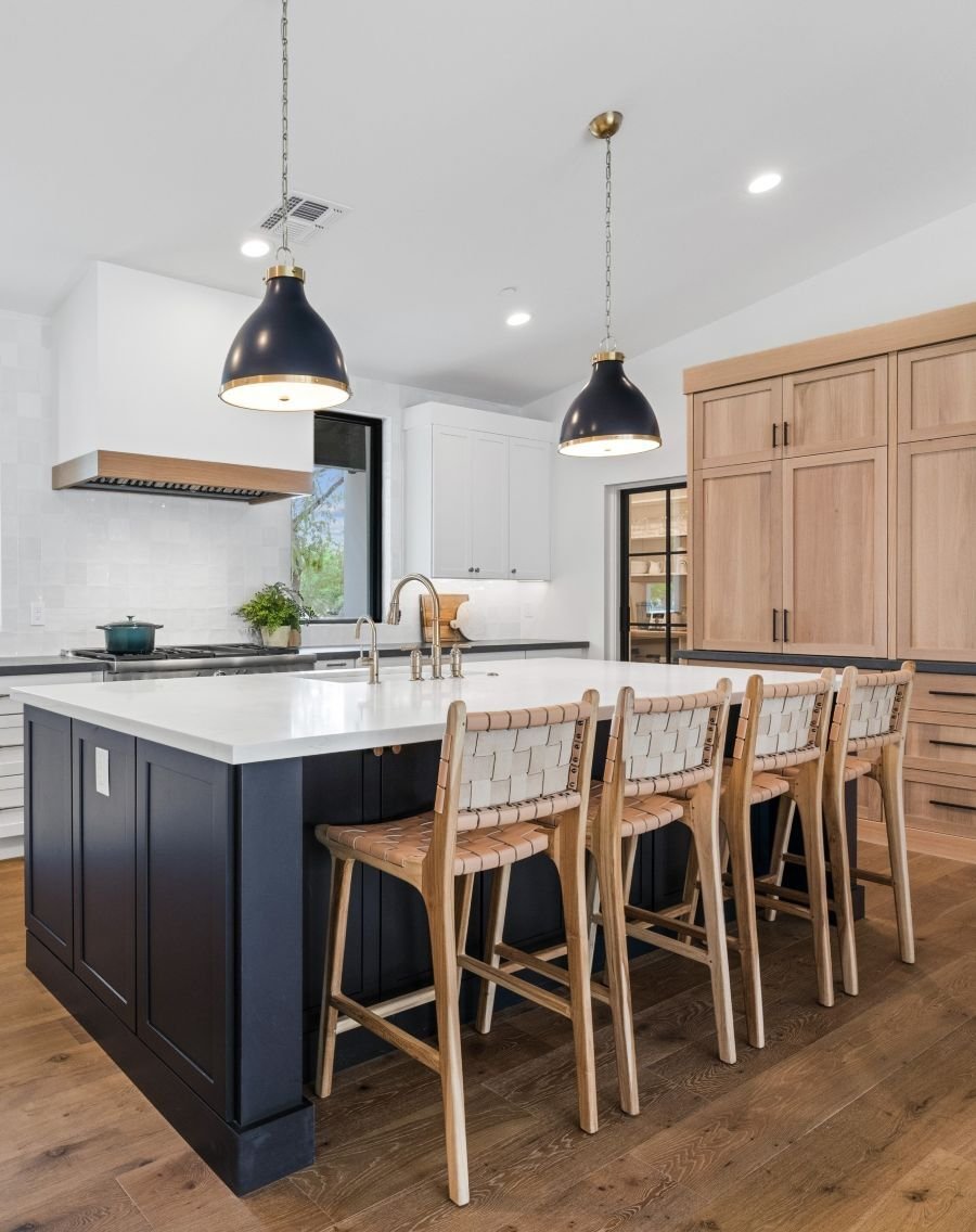 Side angle of kitchen island seating and pendant lights by Trinity Homes AZ