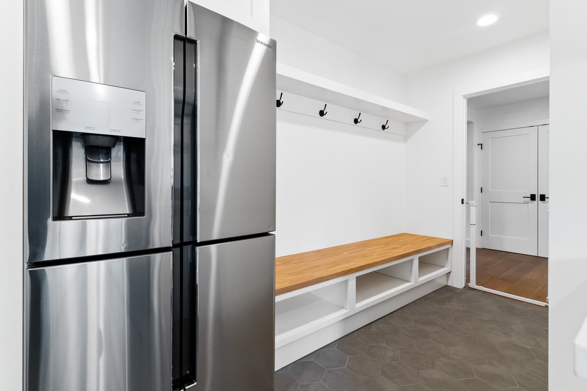 Trinity Homes AZ functional mudroom corner with storage and stainless steel fridge in Paradise Valley, AZ