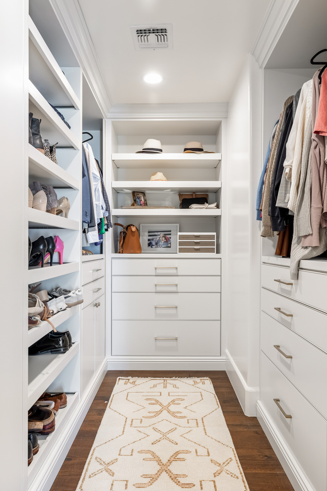 Built-in white closet system with drawers and open shelving in a Scottsdale home by Trinity Homes