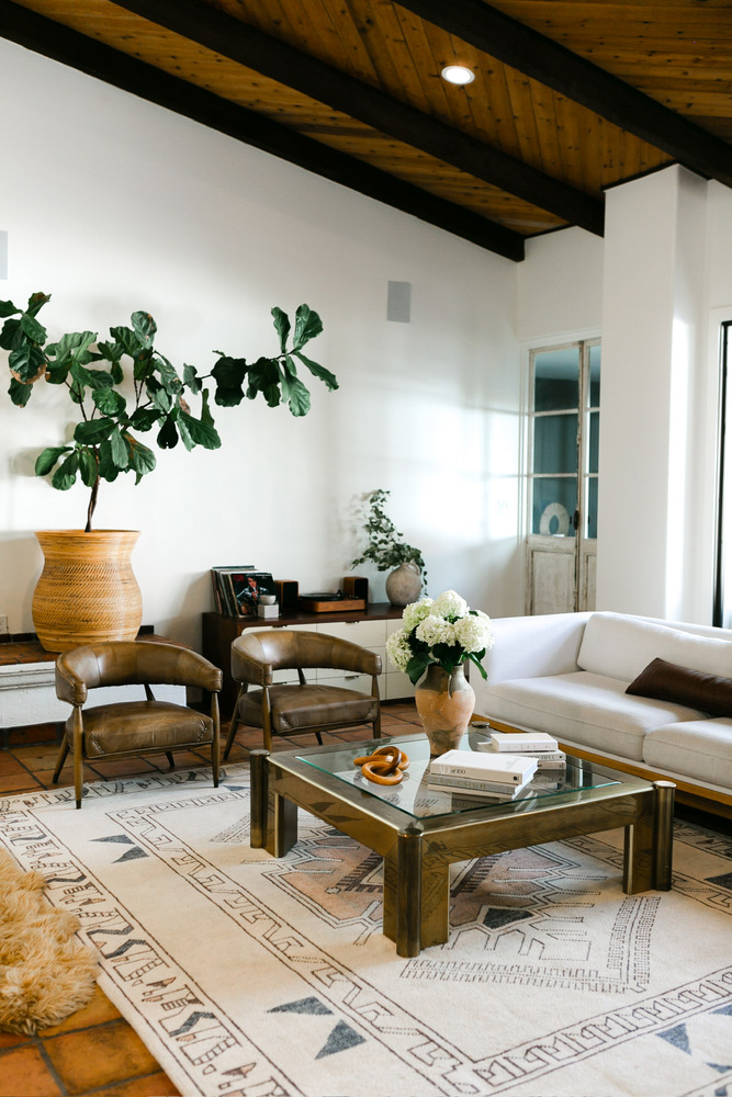 Cozy living room in Phoenix remodeled by Trinity Homes with leather chairs and wood-beam ceiling
