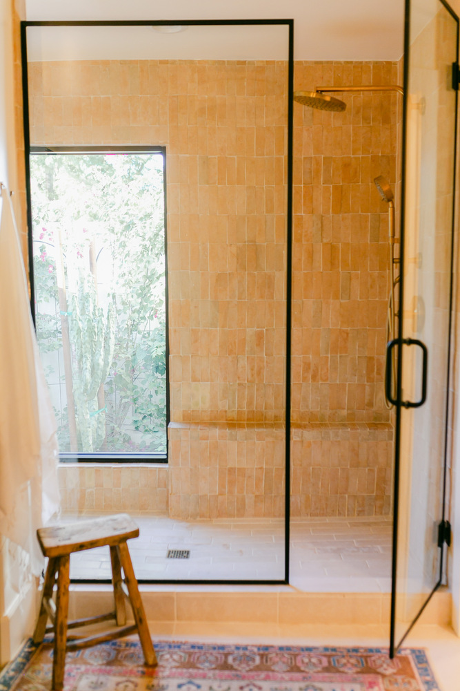 Walk-in shower with warm tile tones in Phoenix whole home renovation by Trinity Homes
