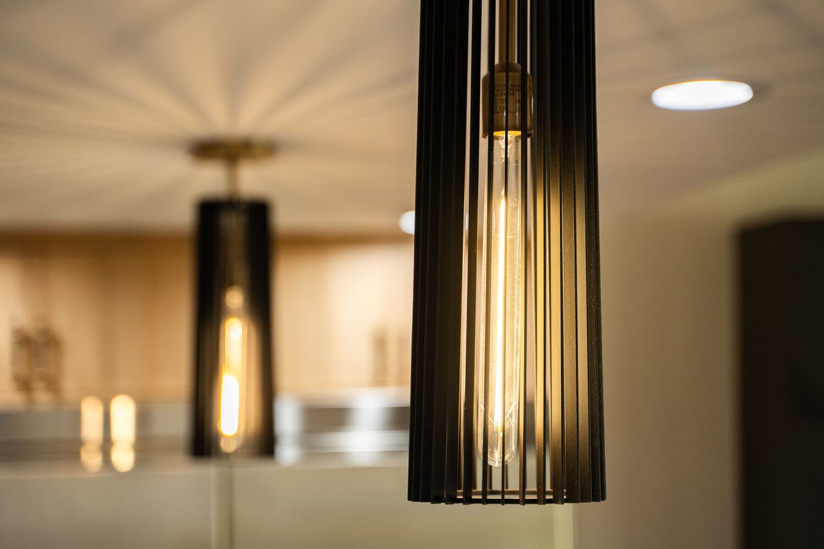 Close-up of black pendant lighting over kitchen island in Scottsdale remodel by Trinity Homes