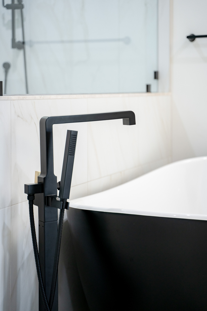 Freestanding black tub with matte black faucet fixture in a Trinity Homes Scottsdale bathroom renovation