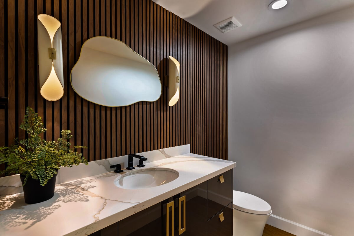 Rainfall shower with marble tile walls and black fixtures in Scottsdale home by Trinity Homes