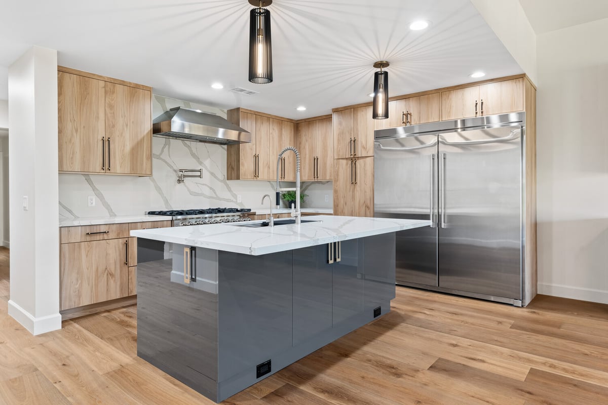 Trinity Homes kitchen remodel showcasing modern pendant lights and sleek wood cabinetry in Scottsdale, AZ