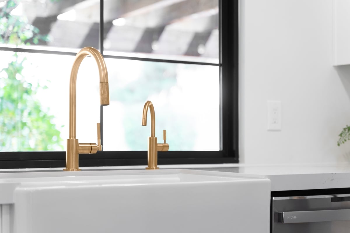 Elegant gold faucet detail in a modern kitchen renovation by Trinity Homes AZ in Chandler, AZ