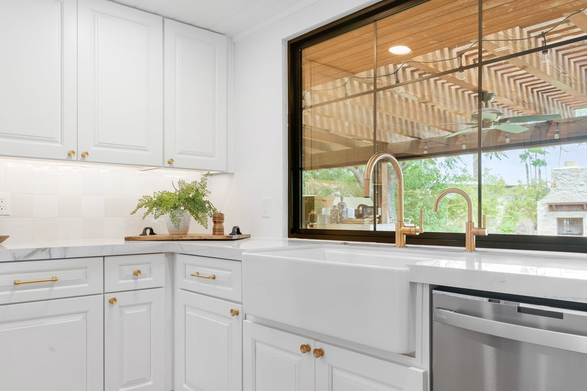 Farmhouse sink with gold fixtures in a custom kitchen by Trinity Homes AZ in Scottsdale AZ