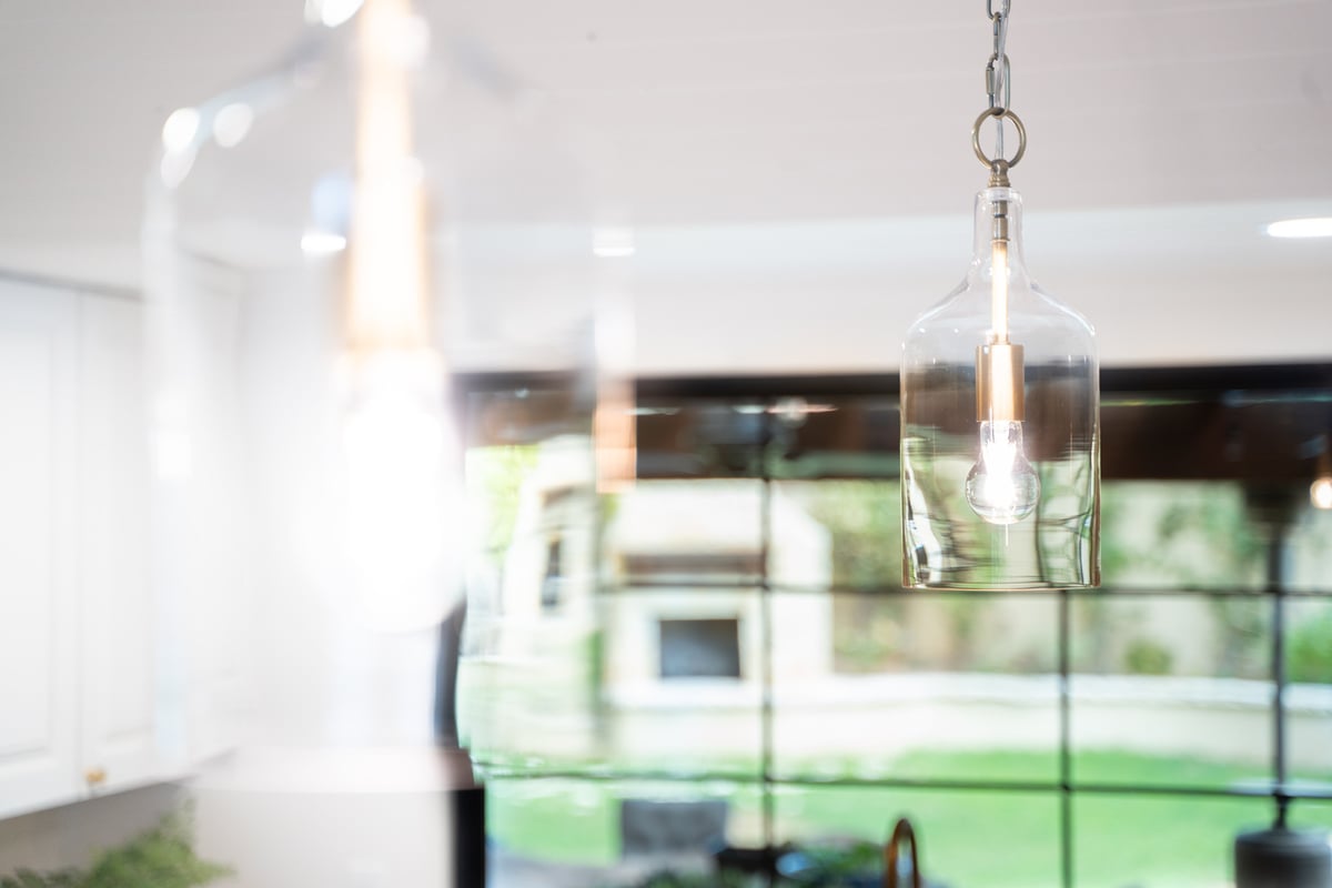 Hanging glass light fixtures in Phoenix AZ kitchen designed by Trinity Homes AZ